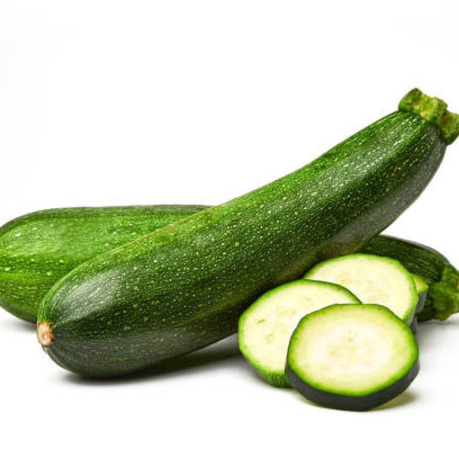 Fresh whole and sliced zucchini isolated on white background. From top view. Courgette zucchini cut into slices