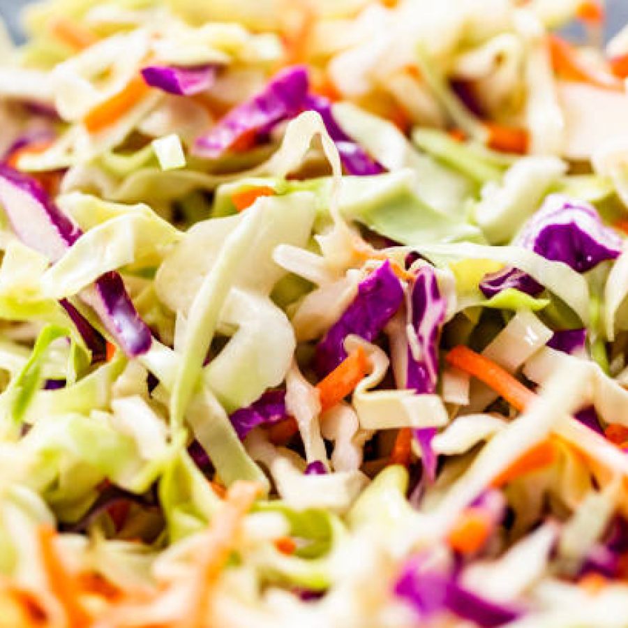 Close up view. Making homemade coleslaw in a glass bowl.