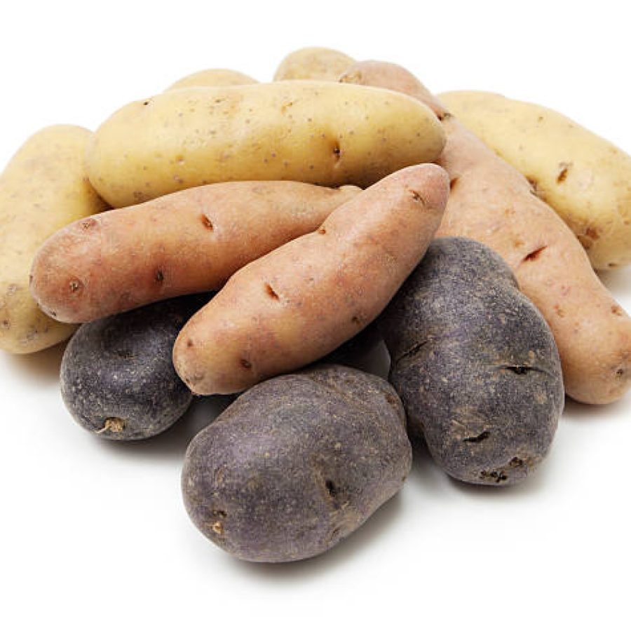 Variety of fingerling potatoes on white background.